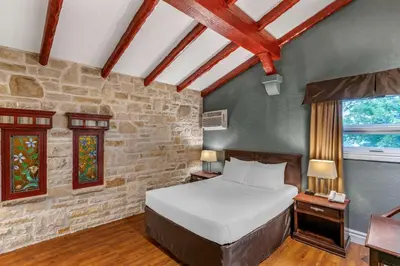 a bedroom with a bed and a stone wall at Econo Lodge Hotel Brossard in Brossard