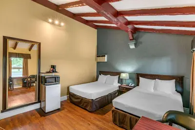 a hotel room with two beds and a mirror at Econo Lodge Hotel Brossard in Brossard