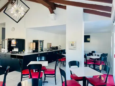 a dining room with tables and red chairs at Econo Lodge Hotel Brossard in Brossard