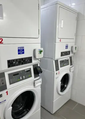 a laundry room with two washer and dryer at Econo Lodge Hotel Brossard in Brossard