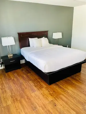 a bedroom with a large bed with two lamps at Econo Lodge Hotel Brossard in Brossard