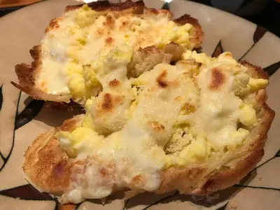 a piece of bread with cheese on it on a plate at A La Carte Bed & Breakfast in Montréal