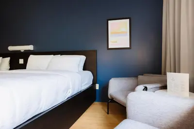 a hotel room with a bed and a couch at Le Dauphin St-Hyacinthe in Saint-Hyacinthe