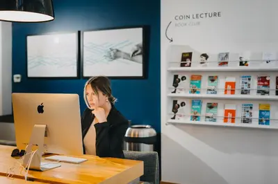 a woman sitting at a desk with a laptop computer at Le Dauphin Montréal Centre-Ville in Montréal