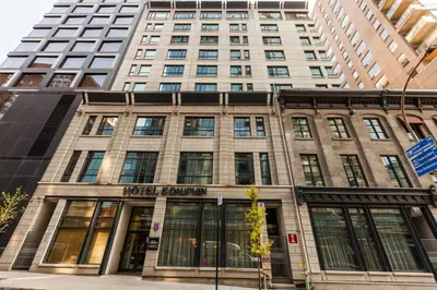 a tall building with windows on a city street at Le Dauphin Montréal Centre-Ville in Montréal