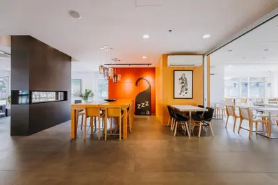 a kitchen and dining room with wooden tables and chairs at Le Dauphin Montréal-Longueuil in Longueuil