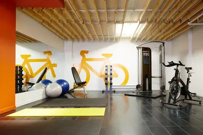 a gym with bikes and exercise equipment on the wall at Le Dauphin Montréal-Longueuil in Longueuil