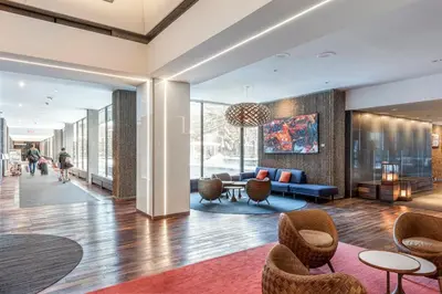 a lobby of a building with chairs and a couch at Hotel Bonaventure Montreal in Montréal