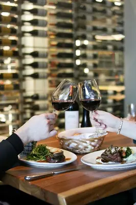 two people are sitting at a table with two glasses of wine at Hotel Bonaventure Montreal in Montréal