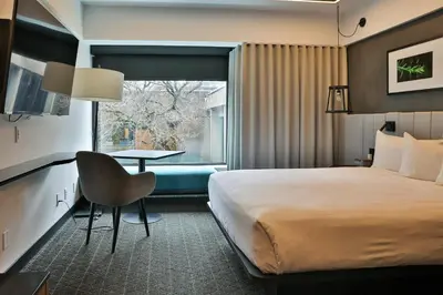 a hotel room with a bed and a table and a window at Hotel Bonaventure Montreal in Montréal