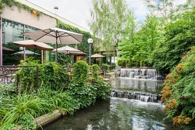 a waterfall in front of a building with a river at Hotel Bonaventure Montreal in Montréal