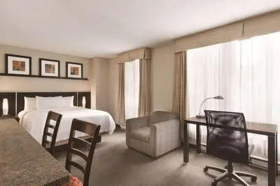a hotel room with a bed and a desk and chair at Embassy Suites by Hilton - Montreal in Montréal