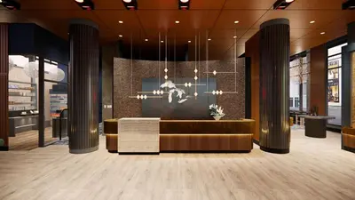 a lobby of a building with a couch and chandelier at Embassy Suites by Hilton - Montreal in Montréal