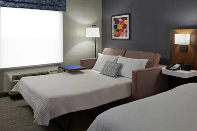 a hotel room with two beds and a window at Hampton Inn & Suites Montreal-Dorval in Dorval