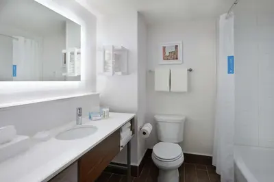 a white bathroom with a toilet and a sink at Hampton Inn & Suites Montreal-Dorval in Dorval