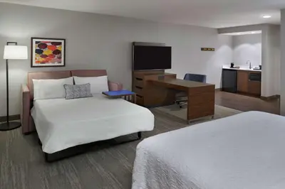 a hotel room with a bed and a desk with a computer at Hampton Inn & Suites Montreal-Dorval in Dorval