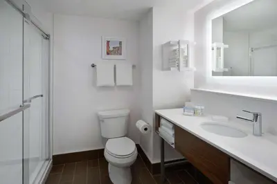 a white bathroom with a toilet and a sink at Hampton Inn & Suites Montreal-Dorval in Dorval