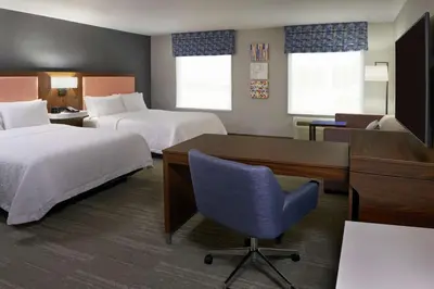 a hotel room with two beds and a desk and a computer at Hampton Inn & Suites Montreal-Dorval in Dorval