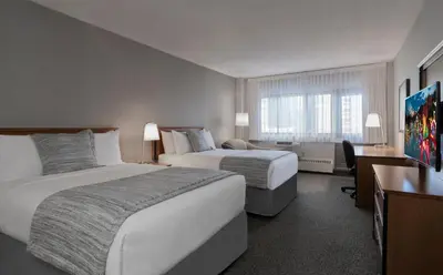 a hotel room with two beds and a window at L'Appartement Hôtel in Montréal