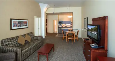 a living room with a couch and a tv and a table at Le Square Phillips Hôtel & Suites in Montréal
