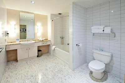 a bathroom with a toilet and a sink and a shower at Le Square Phillips Hôtel & Suites in Montréal