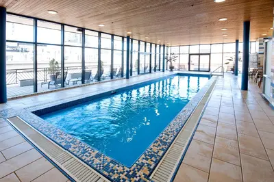 a large swimming pool in a building with windows at Le Square Phillips Hôtel & Suites in Montréal