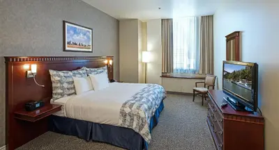a hotel room with a bed and a flat screen tv at Le Square Phillips Hôtel & Suites in Montréal
