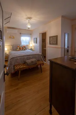 a bedroom with a bed and a table in a room at À Tout Venant B&B in Magog-Orford