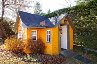 a small yellow house with a white door at À Tout Venant B&B in Magog-Orford