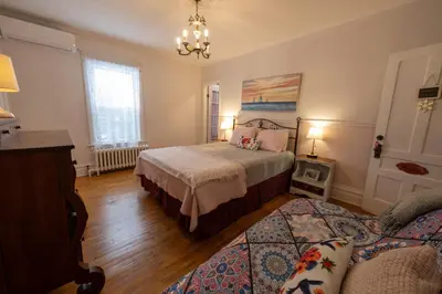 a bedroom with a bed and a couch at À Tout Venant B&B in Magog-Orford