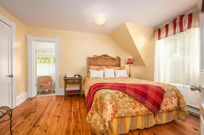 a bedroom with a large bed and a wooden floor at Les Matins de Victoria in Waterloo