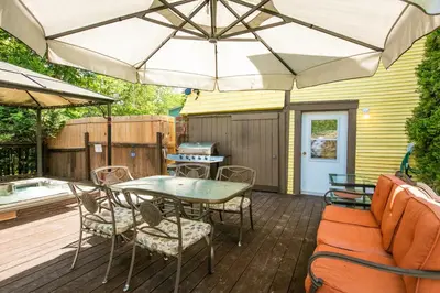 a patio with a table and chairs and an umbrella at Les Matins de Victoria in Waterloo