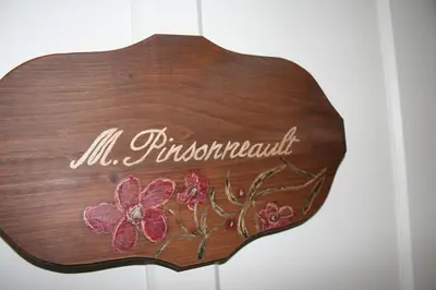 a wooden sign with flowers on it at Les Matins de Victoria in Waterloo