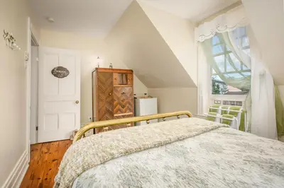 a bedroom with a bed and a window at Les Matins de Victoria in Waterloo