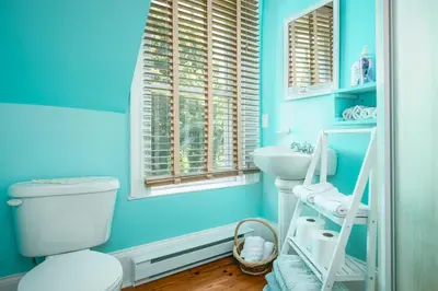 a blue bathroom with a toilet and a sink at Les Matins de Victoria in Waterloo