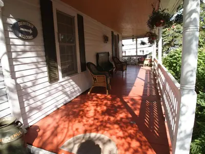 a porch of a house with a rug on it at Au Manoir de la rue Merry in Magog-Orford