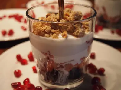 a glass jar filled with yogurt and nuts on a plate at Au Manoir de la rue Merry in Magog-Orford