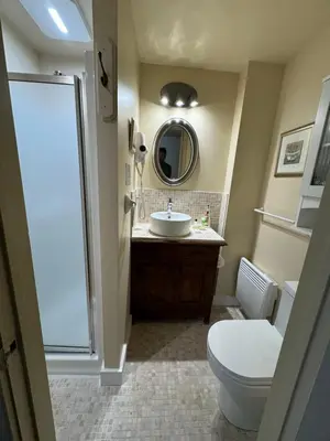 a bathroom with a sink and a toilet and a mirror at Au Manoir de la rue Merry in Magog-Orford