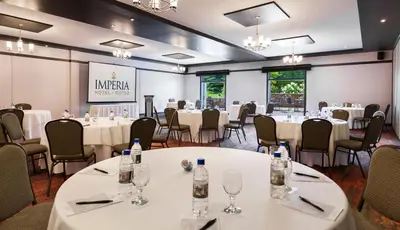 a conference room with tables and chairs and a stage at Imperia Hotel & Suites Saint-Eustache in Saint-Eustache