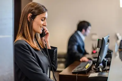 a woman talking on a phone in an office at Imperia Hotel & Suites Saint-Eustache in Saint-Eustache