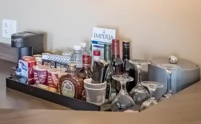 a tray with wine bottles and glasses on a table at Imperia Hotel & Suites Saint-Eustache in Saint-Eustache