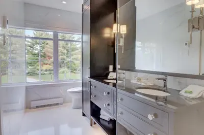 a bathroom with a sink and a toilet and a window at Ripplecove Hotel & Spa in Ayer's Cliff