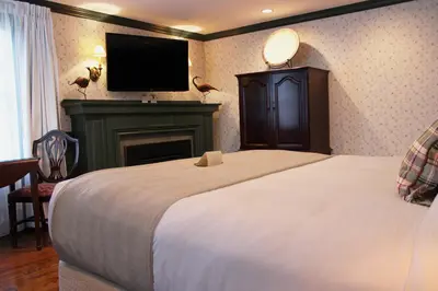 a bedroom with a bed with a fireplace and a television at Ripplecove Hotel & Spa in Ayer's Cliff