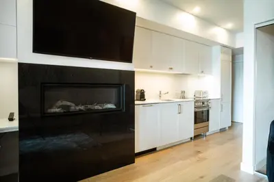 a kitchen with a fireplace with a tv above it at Ripplecove Hotel & Spa in Ayer's Cliff