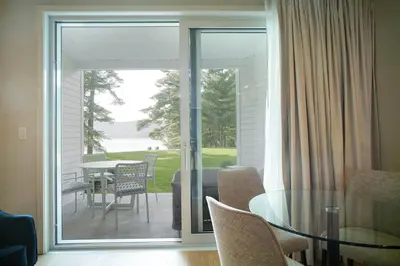 a living room with a glass door leading to a patio at Ripplecove Hotel & Spa in Ayer's Cliff