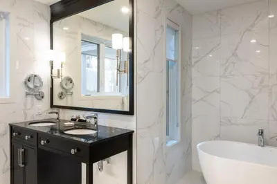 a bathroom with a tub and a sink and a tub and a mirror at Ripplecove Hotel & Spa in Ayer's Cliff