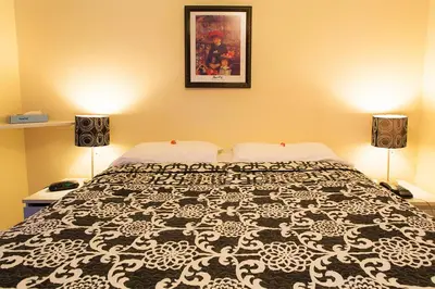 a bedroom with a black and white bed with two lamps at Chalet Beaconsfield Motel in Beaconsfield