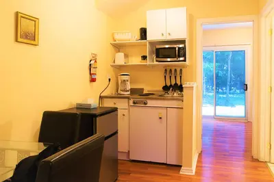 a small kitchen with a stove and a microwave at Chalet Beaconsfield Motel in Beaconsfield