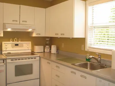 a kitchen with white cabinets and a sink at Arkadia Condo Magog in Magog-Orford