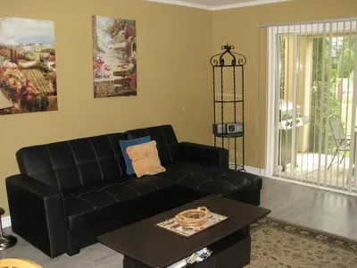 a living room with a black couch and a table at Arkadia Condo Magog in Magog-Orford